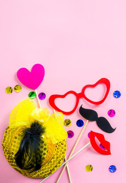 Flat lay view of pink background with fun birthday party decorations props. A lot of room for text.