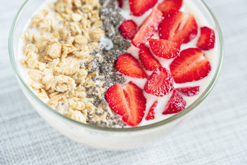 Healthy breakfast superfood smoothie bowl topped with granola and strawberry. close up. delicious berry smoothie bowl. vegan raw food. Selective focus.