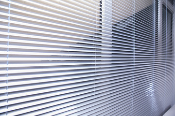 Office blinds. Modern wooden jalousie. Office meeting room lighting range control. venetian blinds by the window . Sunlight coming through venetian blinds by the window .