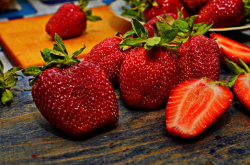 Ripe berries of strawberry directly from a bed to a table. Harvesting of strawberry on a plantation.