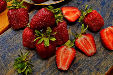 Ripe berries of strawberry directly from a bed to a table. Harvesting of strawberry on a plantation.