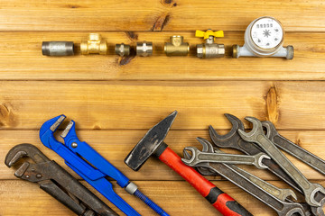 Hand tools for plumbing and parts on wooden background with space for advertising. Set for locksmith or plumber.