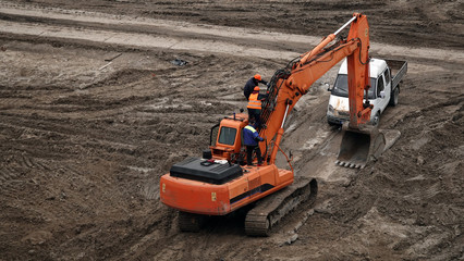 Workers repair equipment on the construction of the zero cycle foundation of the entertainment center