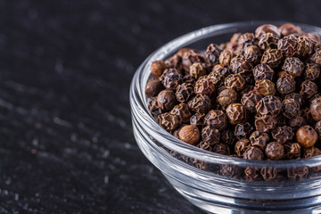 aromatic black pepper on a dark stone background