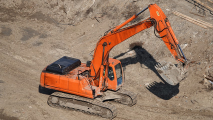 Tractors and excavators work on the construction of the foundation zero cycle