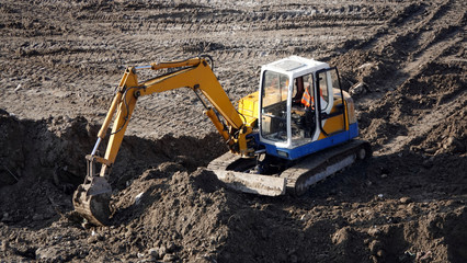 Tractors and excavators work on the construction of the foundation zero cycle