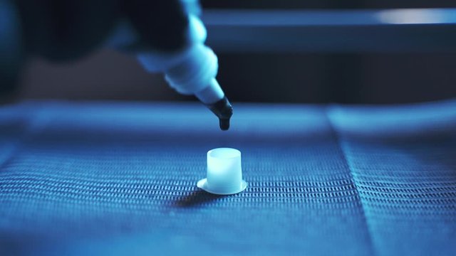 dark ink for tatoo from a bottle dripping into a white plastic cap