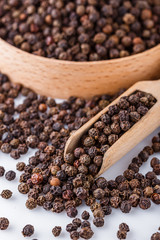 fragrant black pepper on white acrylic background