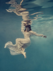 Portrait of a girl in a dress floating underwater