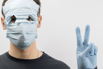 Young european man wearing mask against the corona virus and thumbs up covid 19 man wearing...