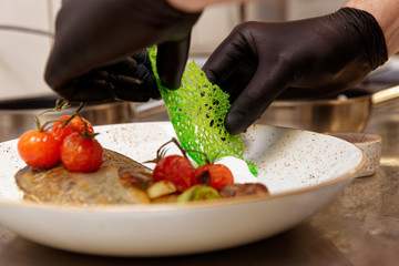 Chef is decorating a fish dish