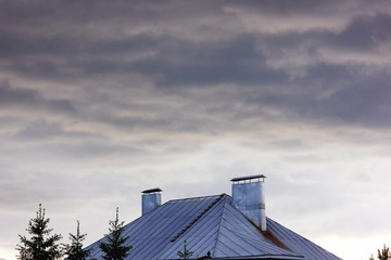 Fototapeta premium the sky is covered with storm clouds on the background of the roof of the house