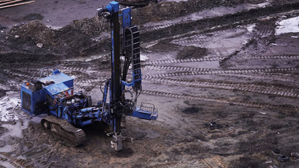 Workers in the mud of a construction site at the stage of excavation; construction of a supermarket...