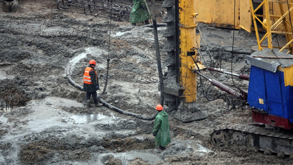 Drilling rig boring the ground pours a hole in the concrete for the foundation of the house