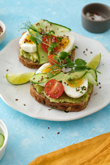 Healthy Breakfast with Wholemeal Bread Toast and Egg with Green Salad, Avocado and Peas.
