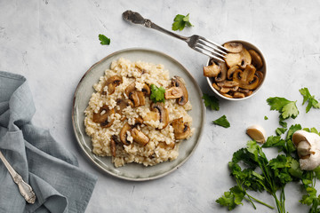 A dish of Italian cuisine - risotto from rice and mushrooms. Top view. Flat lay. Light background.