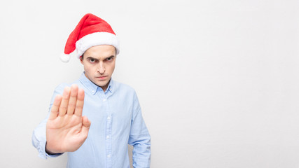 16:9, man in Santa Claus hat showing stop sign, copy space