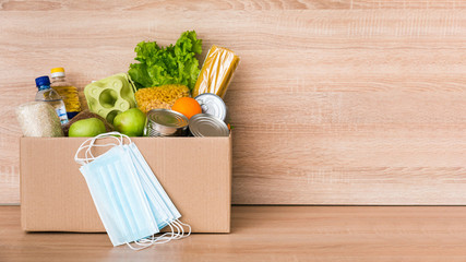 Charity donation box made of cardboard with food, medical masks