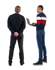 Back view two man in sweater with laptop.