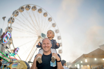 Happy father with his little son in an amusement park