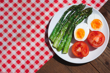 Breakfast with asparagus, egg and tomatoes. Vegetables. Vegetarian food on the table