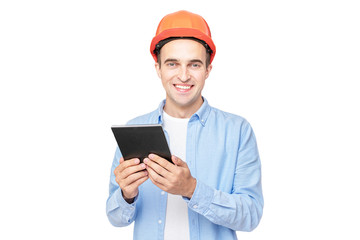 Smiling builder in helmet smiling and uses tablet, isolated, copy space