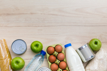 Charity donation food set. Wooden kitchen table background in Scandinavian interior. Flatlay, top view