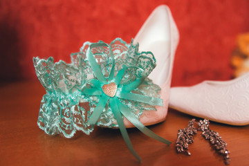 bride's shoes with a garter on the table