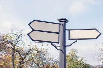 Road signs on the street. Black metal arrows on the signpost. Background, copy space