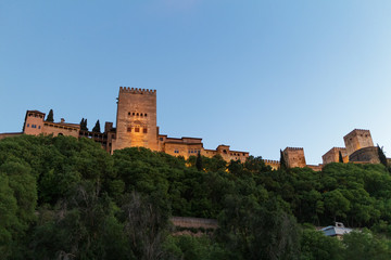 Fototapeta premium La Alhambra de Granada iluminada de noche con cielo azul