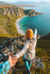Couple traveling in Norway follow holding hands enjoying ocean beach aerial view  adventure lifestyle outdoor summer scandinavian vacations explore Vesteralen islands. - obrazy, fototapety, plakaty
