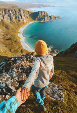 Couple Follow Me Holding Hands Hiking In  Mountains Above Ocean Beach Friends Traveling Together In Norway Adventure Lifestyle Outdoor Summer Vacations Aerial View.