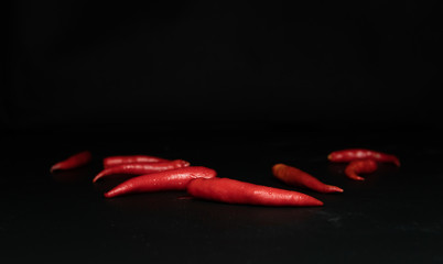Red peppers on a black background Raw materials for cooking