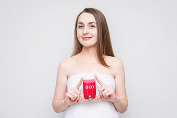 Half naked woman shows deodorant, portrait, white background, copy space