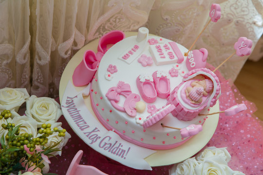 Pink and white theme cake for baby . newborn girl birthday cake . Children's shoes . The child's weight, date of birth, time and length are written . It's a girl baby shower cake .