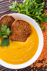 lentil cream soup on rustic wooden background
