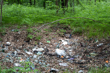 Naklejka na ściany i meble Among the green forest is a large landfill of polluting waste.
