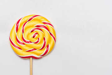 Yellow lollipops in the shape of a round. Bright candy. White background, copy space.