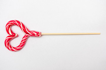 Pink lollipops in the shape of a heart. Bright candy. Love concept and Valentine day. White background