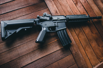 airsoft assault rifle black on brown background