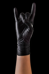 Hand in black gloves showing rock n roll sign or giving the devil horns gesture