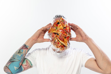 Male face covered with oilcloth, cellophane and unhealthy food, hard to breathe. People lost their faces, can't notice the environmental pollution made by themself. Garbage, problem, breathing.