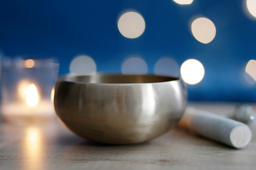 A Tibetan singing bowl is used for spiritual practices. Tibetan singing bowl at the table with candle and crystals. Meditative concept. Meditation at home, alternative medicine. 