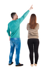 Fototapeta premium Back view of couple in sweater pointing.