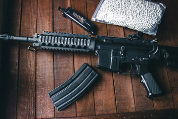 assault rifle and tank loader lie on brown boards