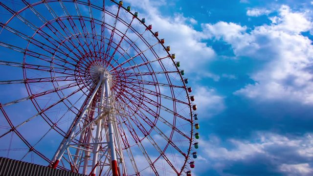 A timelapse of ferris wheel at the amusement park in Odaiba Tokyo daytime medium shot panning