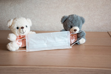 .Toy, cute bears are holding a medical mask. Medical mask in the hands of funny teddy bears....