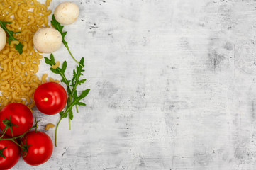 Fototapeta na wymiar Food background, tomatoes lie on pasta near cucumbers and mushrooms, chili peppers