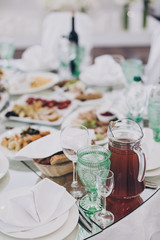 Wedding luxury table setting at reception in restaurant. Stylish glasses for wine, plate with napkin, cutlery and food on tables. Luxury catering service. Christmas feast