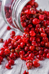pink peppercorns on white wooden rustic background